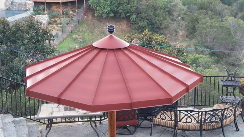 Red metal panel table umbrella on a patio